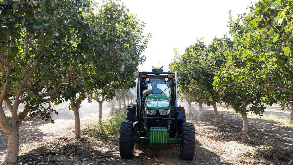 5ML specialty tractor in between trees in an orchard