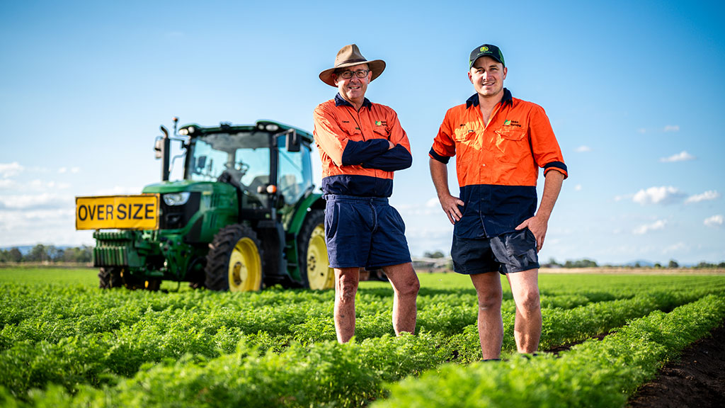 Father and son stand in front of a tractor, farming in the Lockyer Valley for close to 150 years.