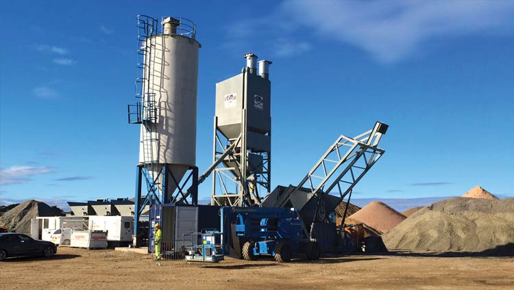 Mixing machine surrounding by piles of materials for cement