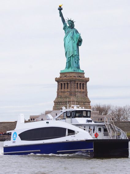 NYC ferry in front of the Statue of Liberty