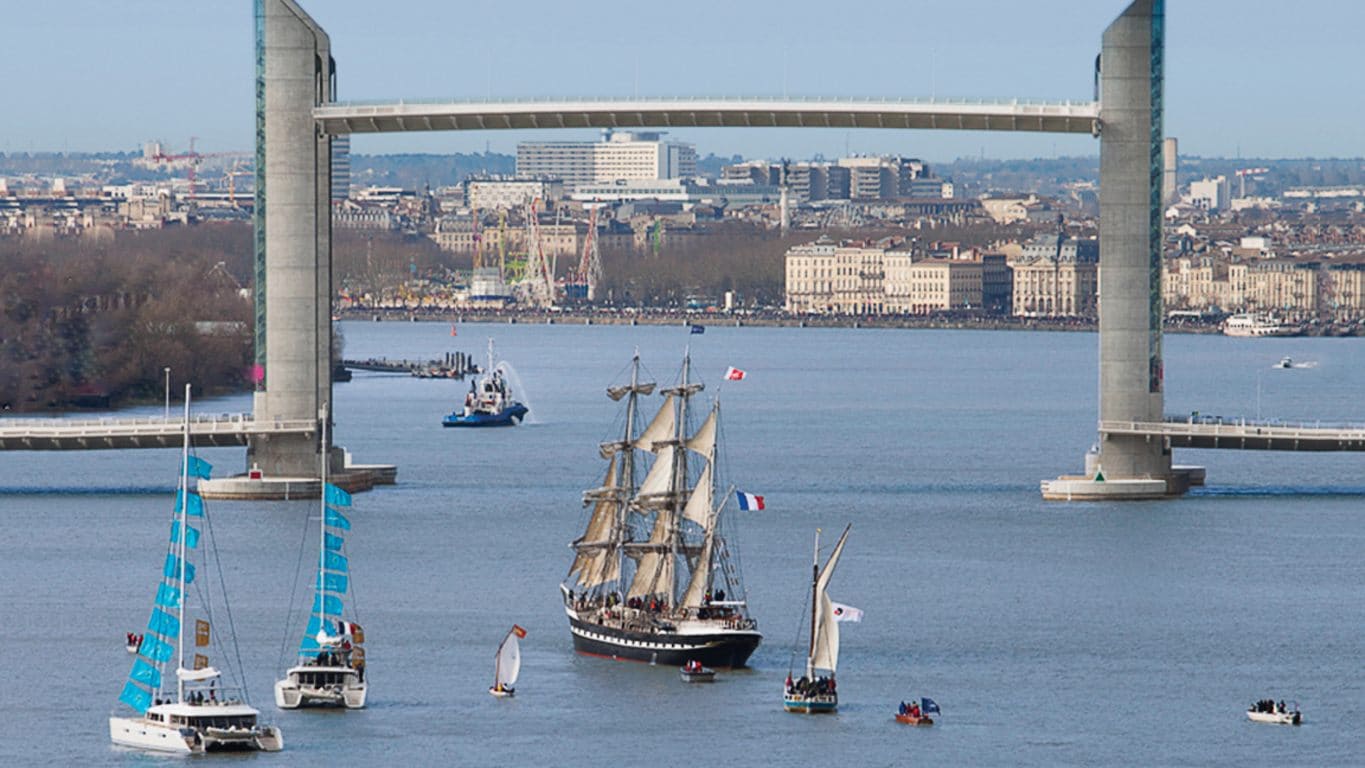 Belem sailing under a bridge