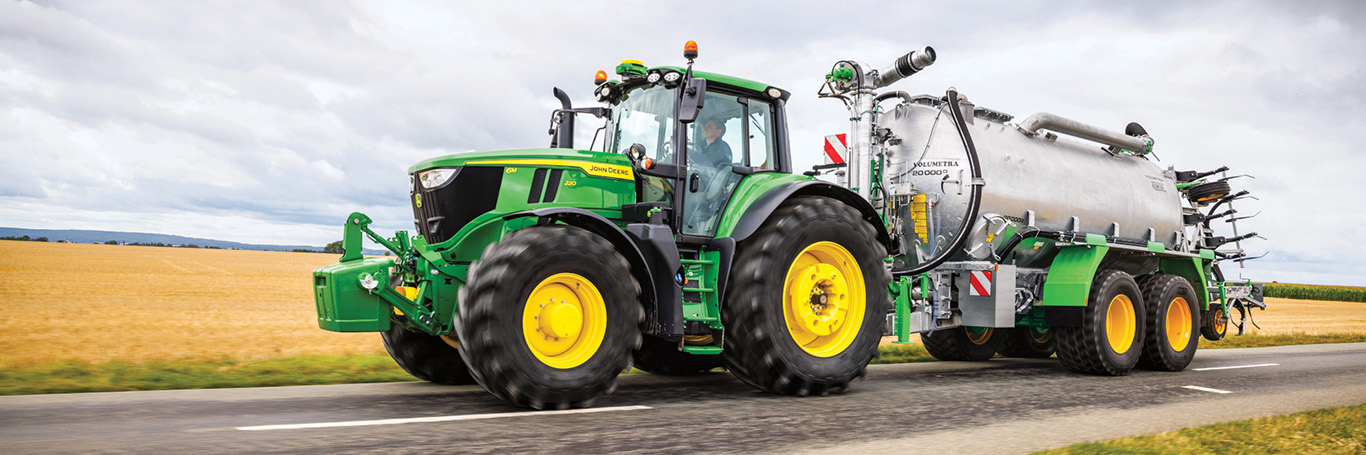 6 series utility tractor next to hay bales and cattle