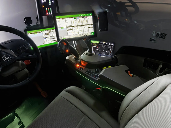 John Deere tractor cab interior with digital displays, multifunction joystick and illuminated controls for precision farming