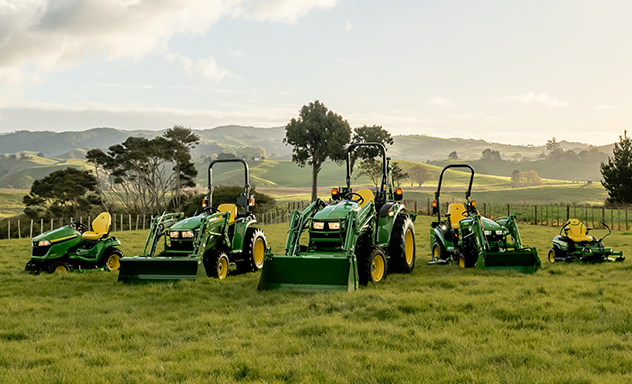 Various lawn tractor models in a field during sunset