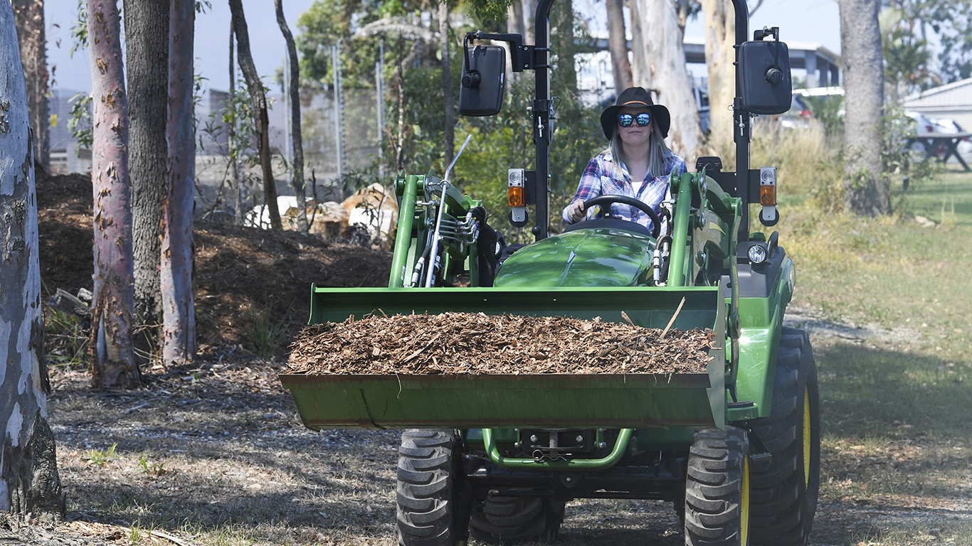 woman driving tractor with loader