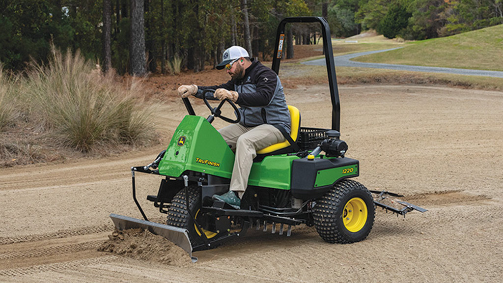 TruFinish™ 1220 Utility Rake Man raking sand on a golf course with a TruFinish™ 1220 Utility Rake