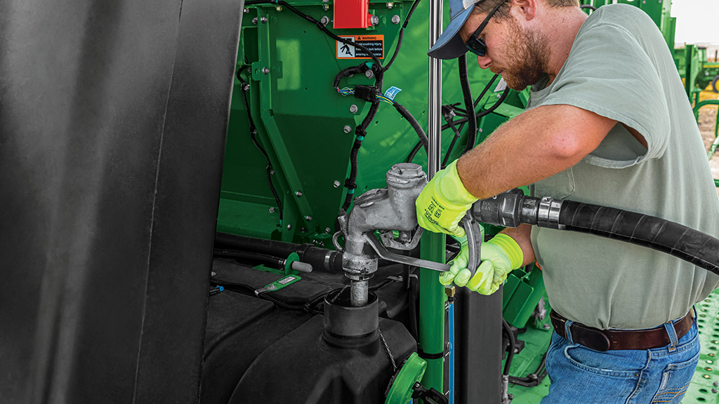 person fueling harvester