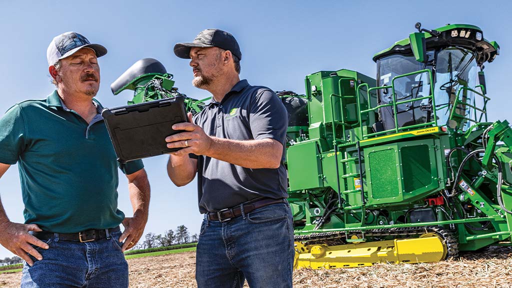 Photo showing two farmers in a field discussing field results on a tablet with a CH Series Sugar Harvester in the background. Photo showing two farmers in a field discussing field results on a tablet with a CH Series Sugar Harvester in the background.