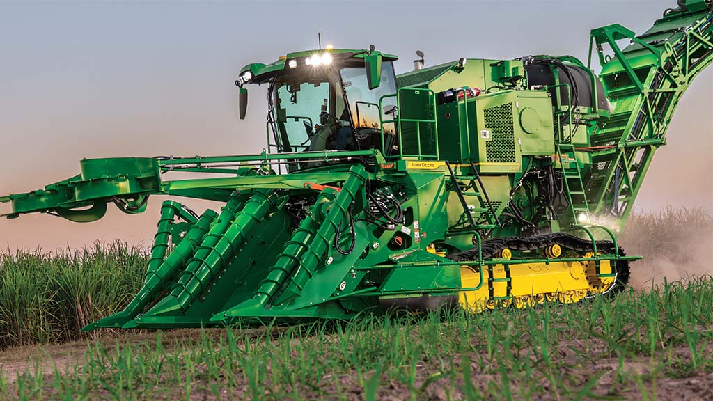 Photo showing a tracked CH Series Sugar Harvester harvesting with lights on at dusk. Photo showing a tracked CH Series Sugar Harvester harvesting with lights on at dusk.