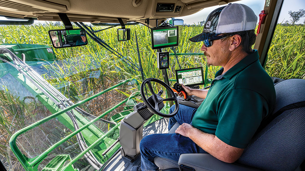 An in-cab, close-up photo of a farmer operating a CH Series Sugar Harvester, with standing crop visible through the front windows. An in-cab, close-up photo of a farmer operating a CH Series Sugar Harvester, with standing crop visible through the front windows.