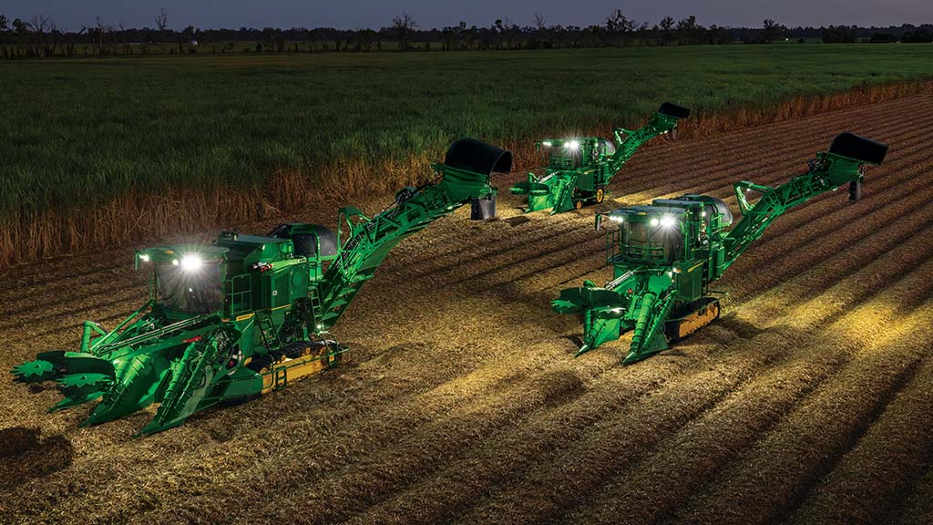 Photo showing three CH Series Sugar Harvesters working with lights in a partially-harvested sugar cane field at night. Photo showing three CH Series Sugar Harvesters working with lights in a partially-harvested sugar cane field at night.