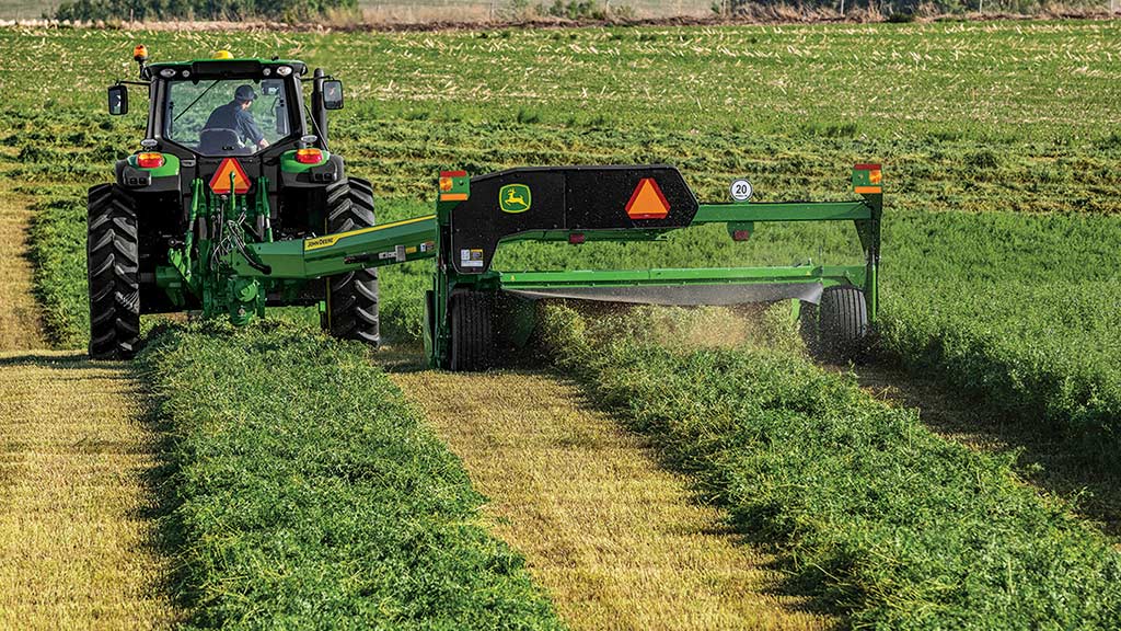 tractor and mower conditioner in a field tractor and mower conditioner in a field