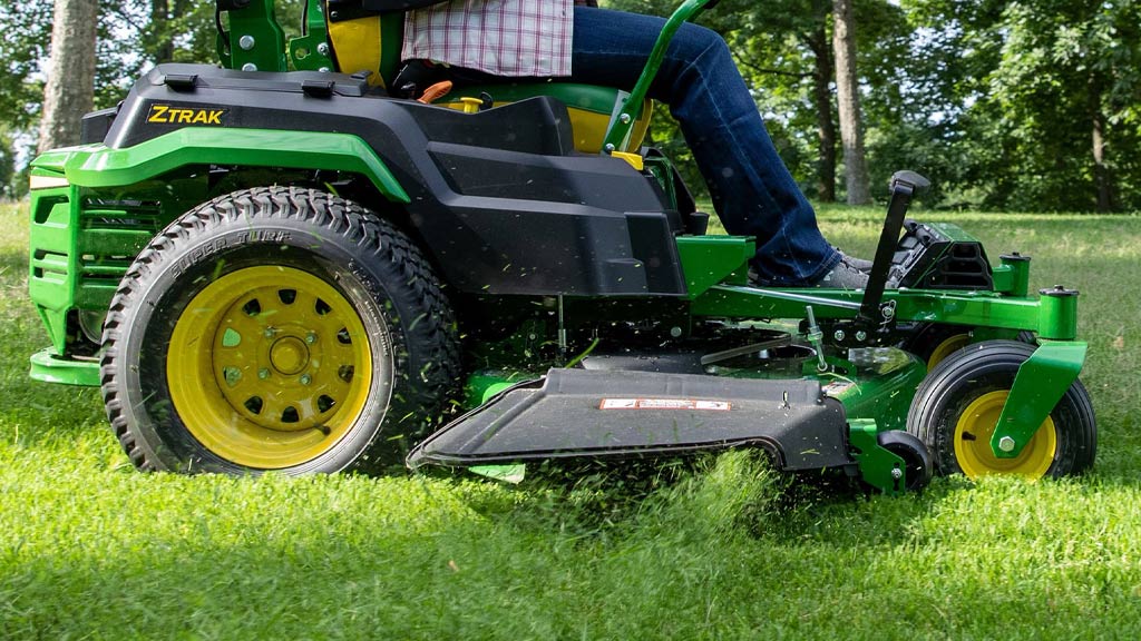 Closeup of John Deere Ztrak mower dispersing grass clippings from its mulch chute.