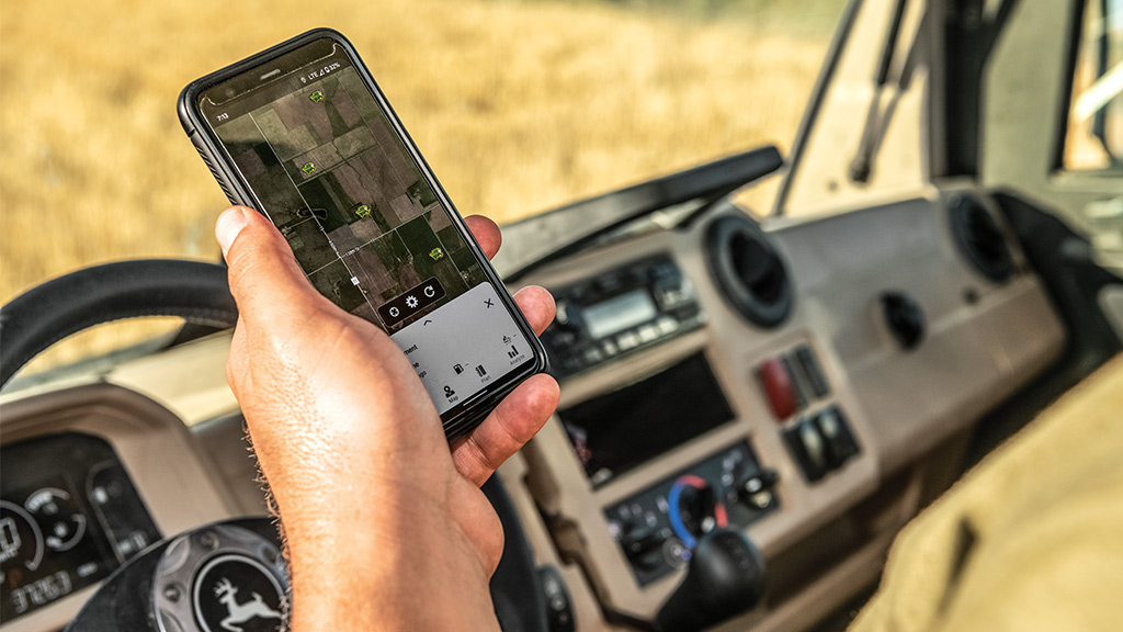 Farmer using John Deere Operations Center in the cab of a Gator looking at small grains agronomic farming data.