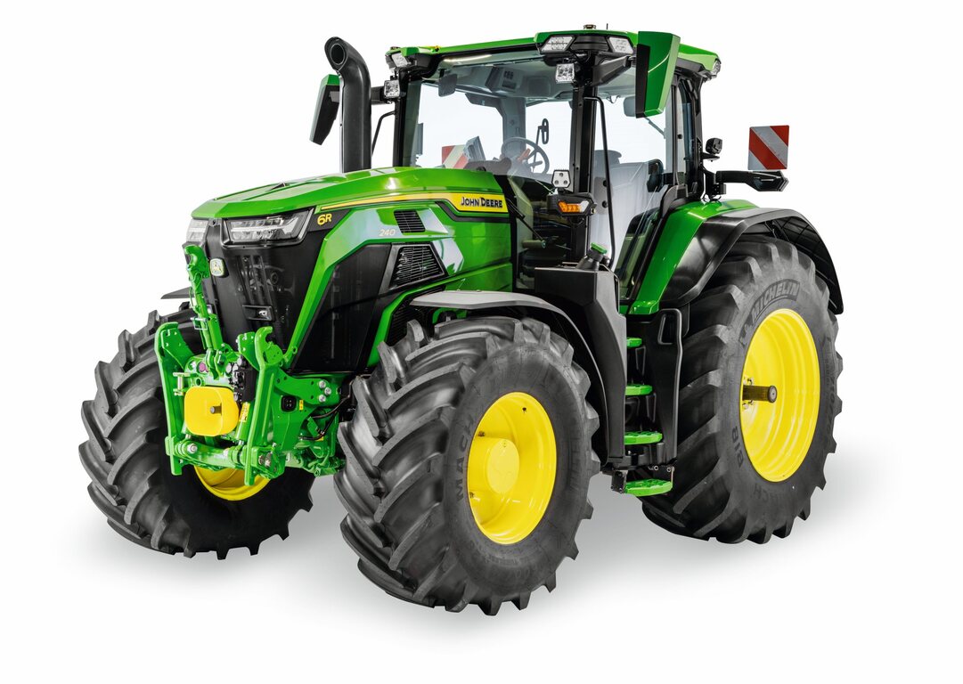 John Deere 6R tractor with enclosed cab and large agricultural tires, shown in a studio view for modern farming operations
