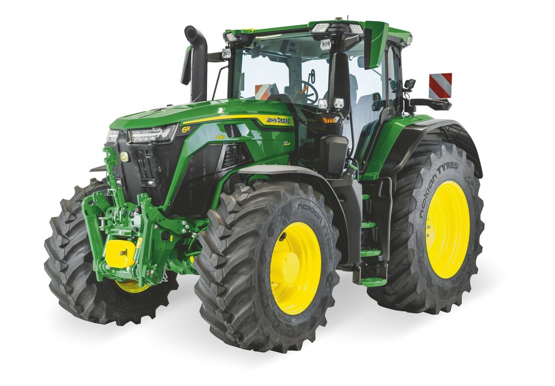 John Deere 6R tractor with enclosed cab and large agricultural tires, shown in a studio view for modern farming operations