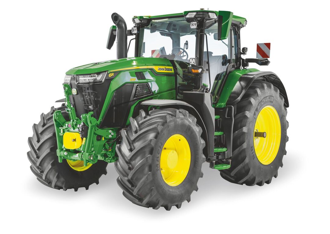 John Deere 6R tractor with enclosed cab and large agricultural tires, shown in a studio view for modern farming operations