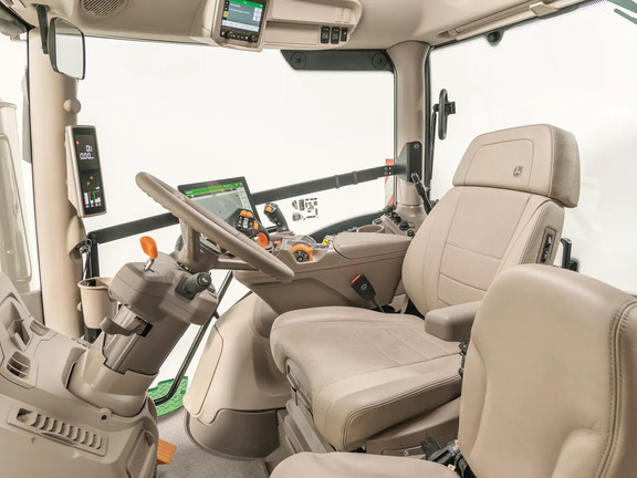 John Deere tractor cab interior with premium seat, touchscreen display and CommandARM controls in a clean studio view.